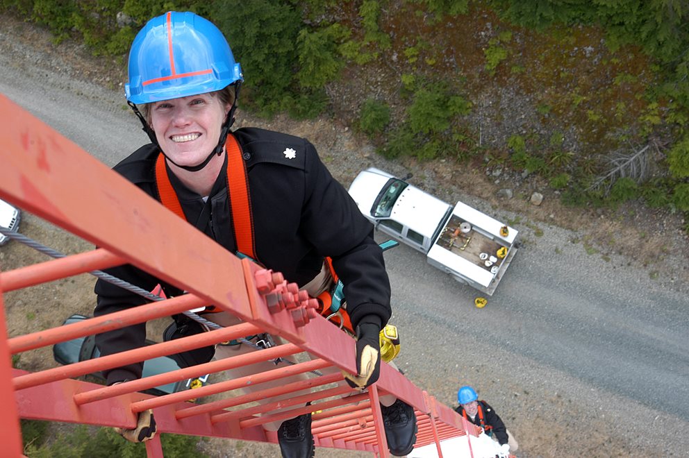 Navy personnel inspecting a telecom tower.