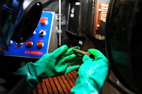 Rubber-gloved hands inspecting a screw